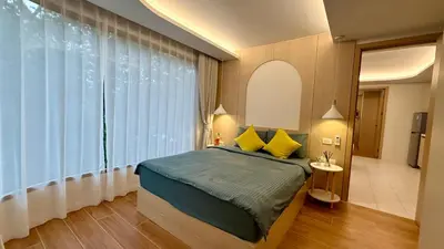 a bedroom with a bed and a large window at Premium 2BR near Kamala Beach, Pool, Gym & Shuttle Bus in Phuket Town