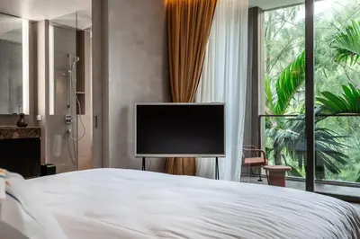 a bedroom with a bed with a flat screen tv at Luxury Penthouse 407sqm Beachfront and private pool in Phuket Town