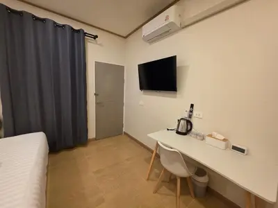 a room with a bed and a table and a tv at ASAP Boutique Phuket in Ban Thalat Choeng Thale