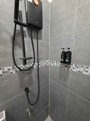 a shower in a bathroom with a shower head at ASAP Boutique Phuket in Ban Thalat Choeng Thale