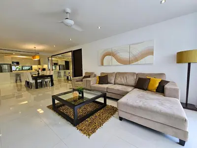 a living room with a couch and a table at Stylish 2 Bedroom Apartment with pool access in Surin in Surin Beach