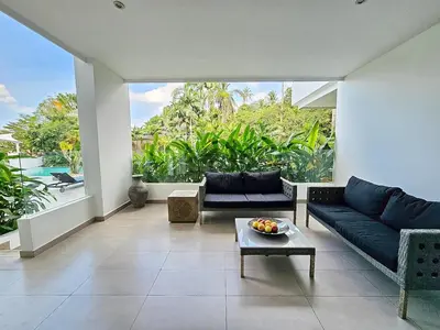 a living room with a couch and a table at Stylish 2 Bedroom Apartment with pool access in Surin in Surin Beach