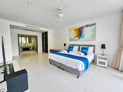 a bedroom with a large bed with blue pillows at Stylish 2 Bedroom Apartment with pool access in Surin in Surin Beach
