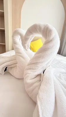 a white towel on a bed with a yellow pillow at Fantasea Kamala 1 BR Near Fantasea Show & Beach 505 in Phuket Town