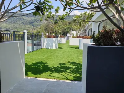 a garden with a fence and green grass at Fantasea Kamala 1 BR Near Fantasea Show & Beach 505 in Phuket Town