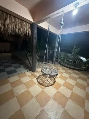 a swing in a room with a tile floor at Дом 2 этажа 2 комнаты, с большой территорией in Ban Na Kok