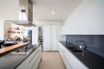 a kitchen with white cabinets and black counter tops at \u5361\u9a6c\u62c9\u6d77\u6ee9\u4e00\u7ebf\u6d77\u666f6\u5367\u522b\u5885 \u5df4\u4e1c\u9152\u5427\u885710\u5206\u949f\u5230\u8fbe\u76f4\u901a\u6d77\u6ee9\u5bb6\u6d77\u666fspa\u6f02\u6d6e\u8336 in Phuket Town