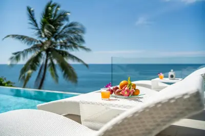 a table with a bowl of fruit next to a pool at \u5361\u9a6c\u62c9\u6d77\u6ee9\u4e00\u7ebf\u6d77\u666f6\u5367\u522b\u5885 \u5df4\u4e1c\u9152\u5427\u885710\u5206\u949f\u5230\u8fbe\u76f4\u901a\u6d77\u6ee9\u5bb6\u6d77\u666fspa\u6f02\u6d6e\u8336 in Phuket Town