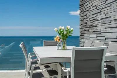 a table with chairs and a vase of flowers at \u5361\u9a6c\u62c9\u6d77\u6ee9\u4e00\u7ebf\u6d77\u666f6\u5367\u522b\u5885 \u5df4\u4e1c\u9152\u5427\u885710\u5206\u949f\u5230\u8fbe\u76f4\u901a\u6d77\u6ee9\u5bb6\u6d77\u666fspa\u6f02\u6d6e\u8336 in Phuket Town