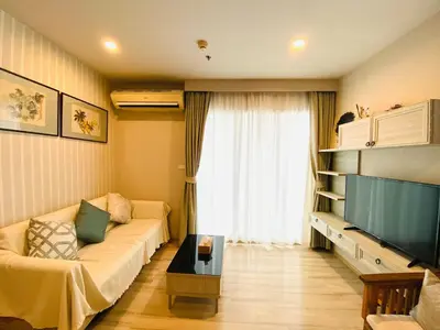a living room with a couch and a television at The Base Height Condo with Rooftop infinity pool in Ban Sam Kong