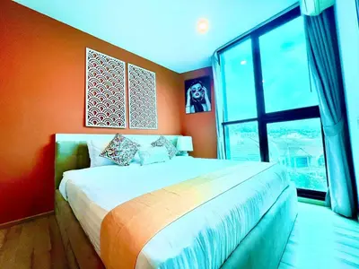 a bedroom with a large bed and a window at The Base Height Condo with Rooftop infinity pool in Ban Sam Kong