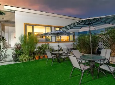 a table and chairs with umbrellas on a lawn at \u666e\u5409\u5c9bYona\u8c6a\u534e\u578b\u56db\u5367\u6cf3\u6c60\u522b\u58851\u53f7 in Ban Bang La