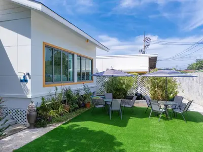 a backyard with a table and chairs and umbrellas at \u666e\u5409\u5c9bYona\u8c6a\u534e\u578b\u56db\u5367\u6cf3\u6c60\u522b\u58851\u53f7 in Ban Bang La