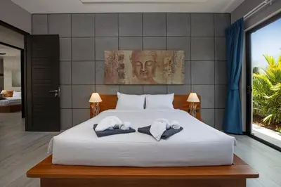 a bedroom with a white bed with two towels at Stylish 4 bdrs new brand pool villa at Rawai kokmakham 1 in Rawai Beach