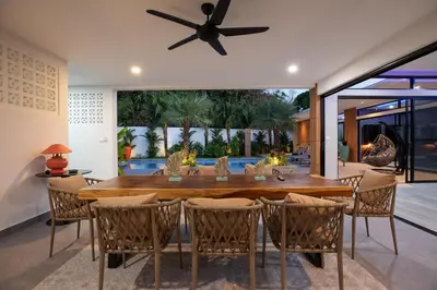 a dining room with a large wooden table and chairs at Stylish 4 bdrs new brand pool villa at Rawai kokmakham 1 in Rawai Beach