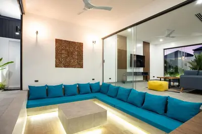 a living room with a blue couch at Superb 3-bedrooms pool villa in Rawai, Naiharn villa Moana in Rawai Beach