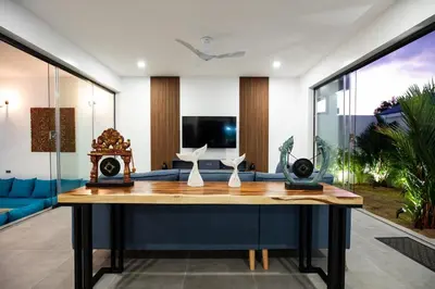 a living room with a table and a blue couch at Superb 3-bedrooms pool villa in Rawai, Naiharn villa Moana in Rawai Beach