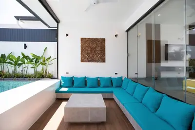 a living room with a blue couch and a pool at Superb 3-bedrooms pool villa in Rawai, Naiharn villa Moana in Rawai Beach
