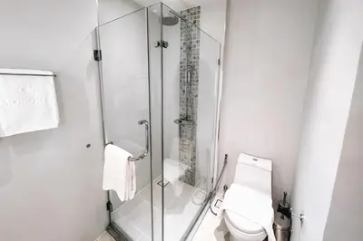 a glass shower in a bathroom with a toilet at Solara Stays Phuket in Bang Tao Beach