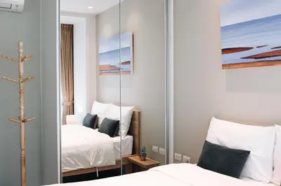 a bedroom with two beds and a mirror at Solara Stays Phuket in Bang Tao Beach