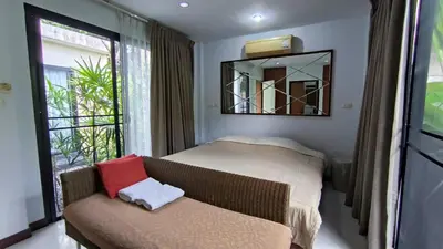 a bedroom with a bed and a mirror and a couch at Rosemary Phuket in Ban Tha Rua
