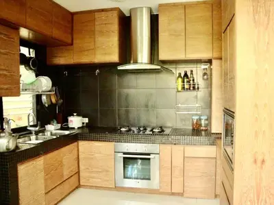 a kitchen with wooden cabinets and a stove top oven at Rosemary Phuket in Ban Tha Rua