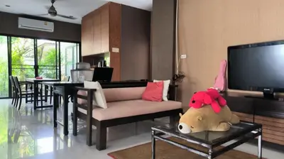 a living room with a couch and a tv at Rosemary Phuket in Ban Tha Rua