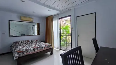a bedroom with a bed and a mirror and a window at Rosemary Phuket in Ban Tha Rua