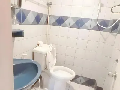 a bathroom with a white toilet and a blue sink at XX Mitr Inn - Phuket Old Town in Phuket Town