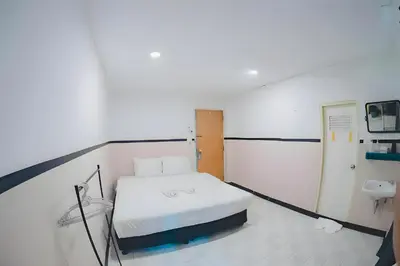 a hospital room with a bed and a bathroom at XX Mitr Inn - Phuket Old Town in Phuket Town