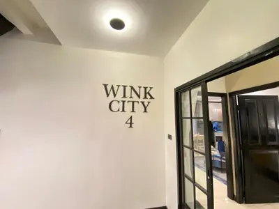 a white wall with a sign that reads wink city at Wink City 4th Patong in Patong Beach