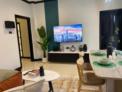 a living room with a table and a tv at Wink City 4th Patong in Patong Beach