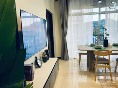 a dining room with a table and a large window at Wink City 4th Patong in Patong Beach