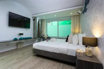a bedroom with a large bed and a television at Seaview 10 bedroom villa Bangtao beach area in Ban Thalat Choeng Thale