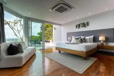 a bedroom with a large bed and a couch at Seaview 10 bedroom villa Bangtao beach area in Ban Thalat Choeng Thale