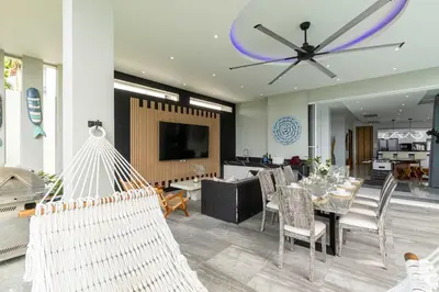 a living room with a dining table and a ceiling fan at Seaview 10 bedroom villa Bangtao beach area in Ban Thalat Choeng Thale