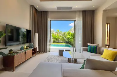 a living room with a couch and a tv at Modern 3BR Pool Villa T-Breeze in Laguna Phuket