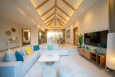 a living room with a white couch and a tv at Modern 3BR Pool Villa T-Breeze in Laguna Phuket