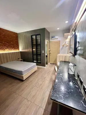 a bedroom with a bed and a desk in it at Bang Tao cozy studio in Ban Thalat Choeng Thale