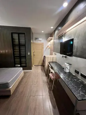 a bedroom with a bed and a desk in a room at Bang Tao cozy studio in Ban Thalat Choeng Thale