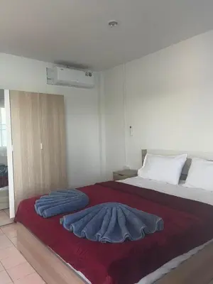a bedroom with a bed with two pillows on it at Water's Edge Resort , in Panwa Beach