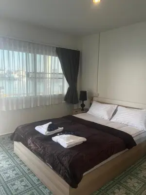 a bedroom with a large bed with towels on it at Water's Edge Resort , in Panwa Beach