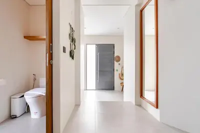 a hallway with a toilet and a mirror at Stylish Mansion for Leisure with Garden & Pool in Laguna Phuket