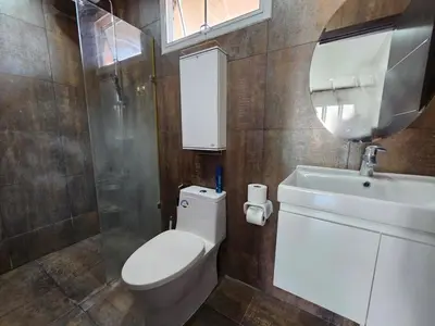 a bathroom with a toilet and a sink and a mirror at Modern 3-Bedroom Townhome in Kamala in Kamala Beach
