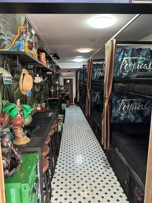 a room with a long aisle with a table and shelves at Tropical Vibes Mini Hostel in Phi Phi Don