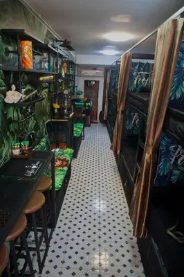 a room with a corridor with chairs and a table at Tropical Vibes Mini Hostel in Phi Phi Don