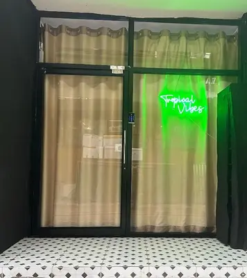 a glass door with a sign in a window at Tropical Vibes Mini Hostel in Phi Phi Don