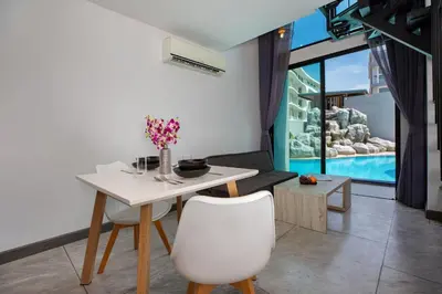 a dining room with a white table and chairs at Poolside Duplex In Nai harn UTL A102 in Rawai Beach