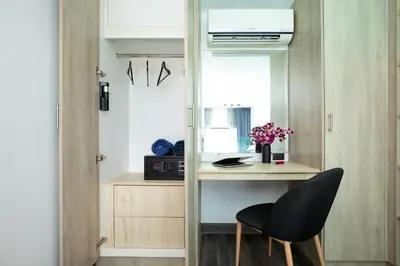 a room with a desk and a chair and a mirror at Poolside Duplex In Nai harn UTL A102 in Rawai Beach