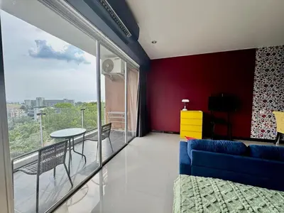 a living room with a blue couch and a table at Stylish Sea view Chic condo in Karon Beach